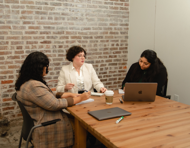 Three people at the table engaging in discussion.