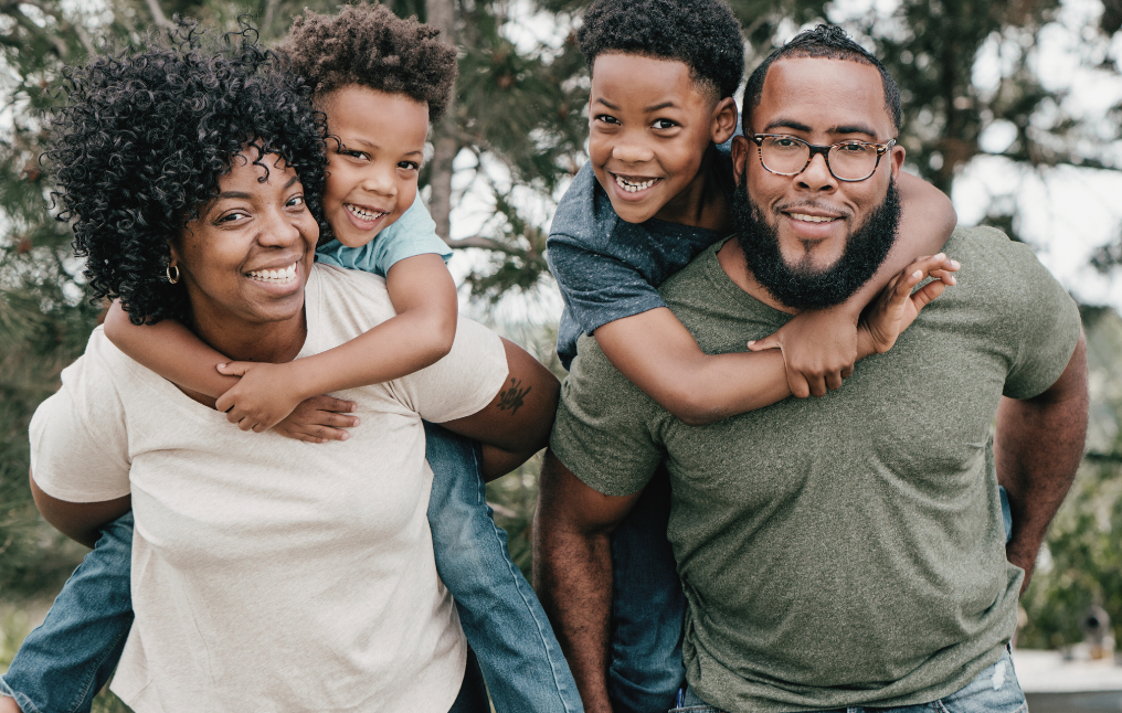 A family of four smiling at the camera.